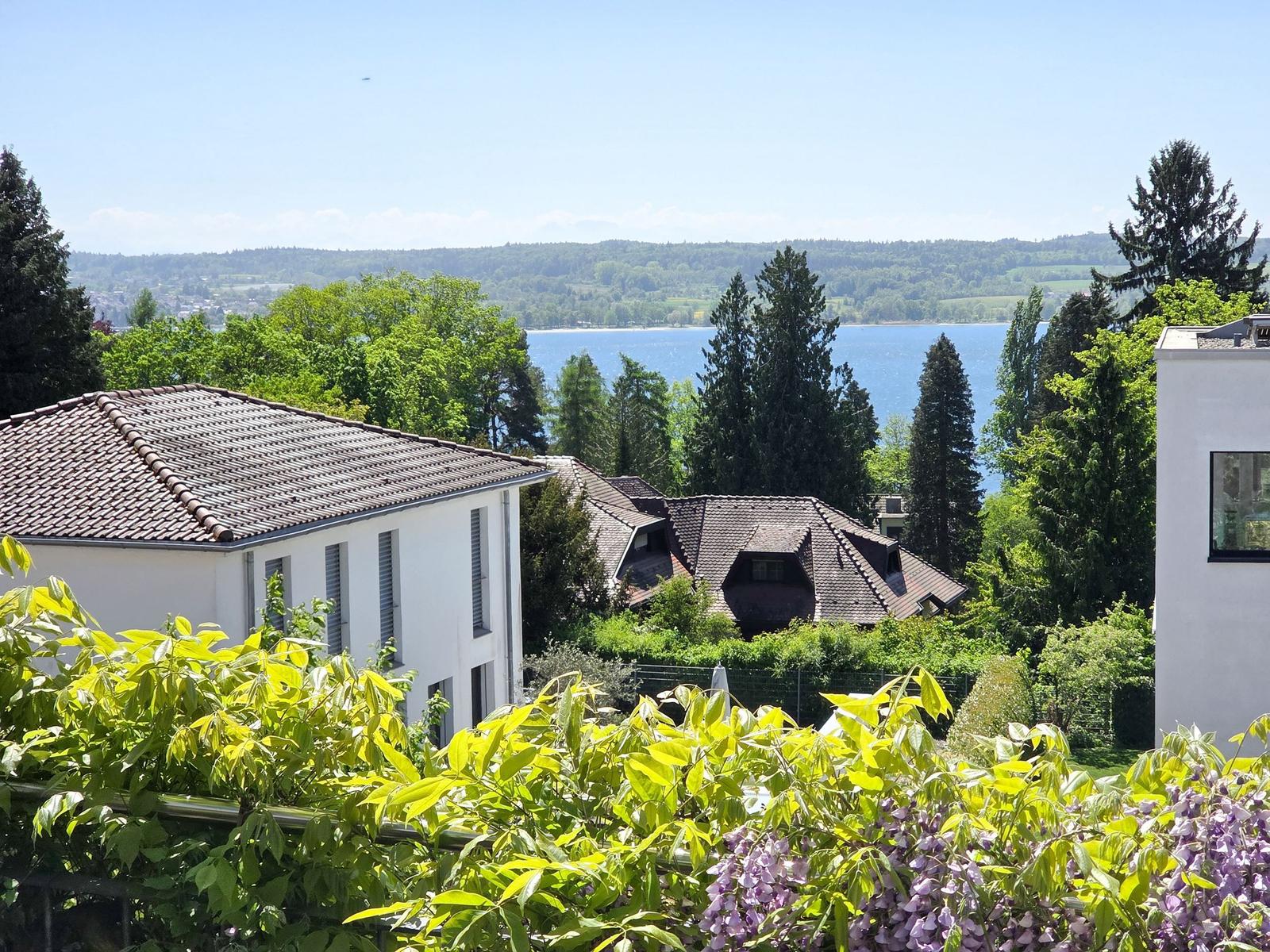 Haus mit Blick auf See und grüne Hügel