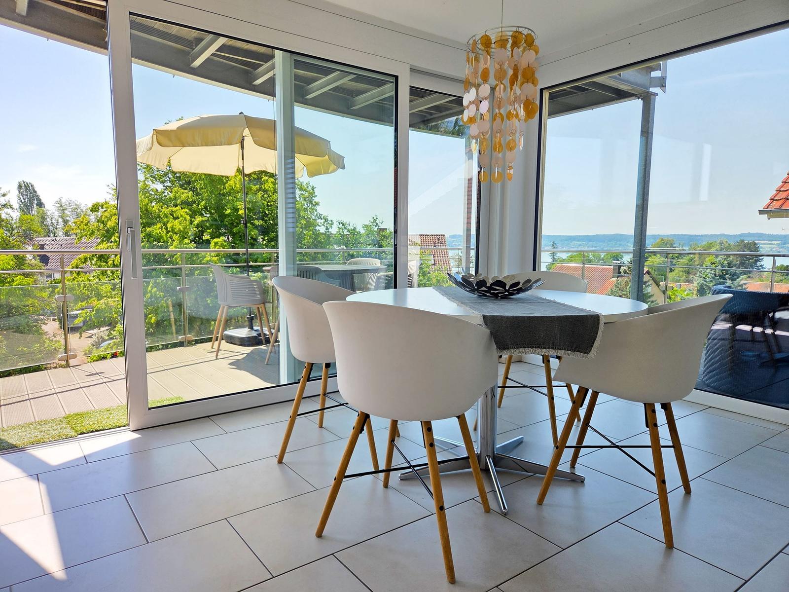 Esstisch mit Stühlen und Balkon mit Sicht auf Landschaft