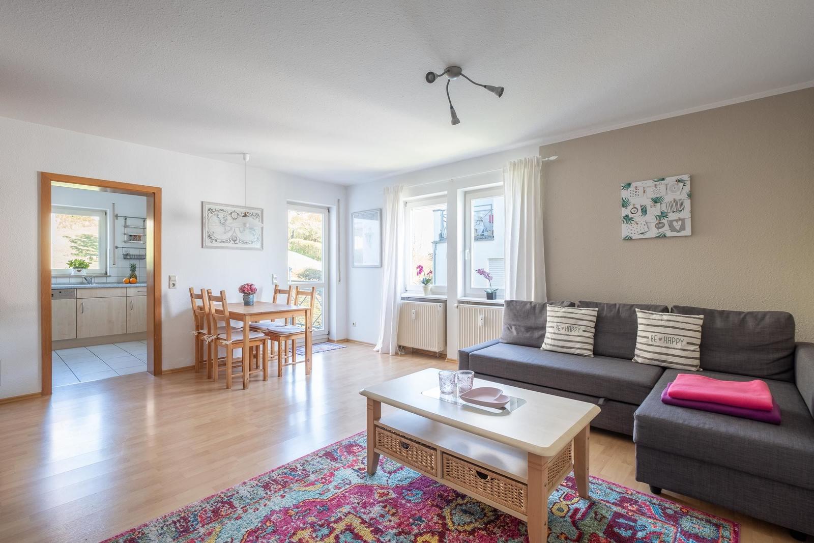 Wohn- und Essbereich mit Sofa, Esstisch und Blick in die Küche.
