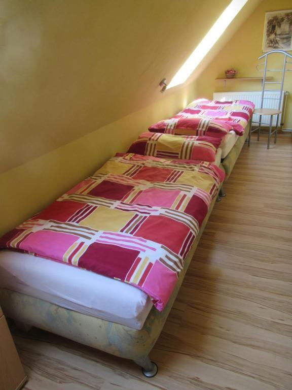Drei Schlafplätze in einem Dachzimmer mit Holzboden und Dachschräge.