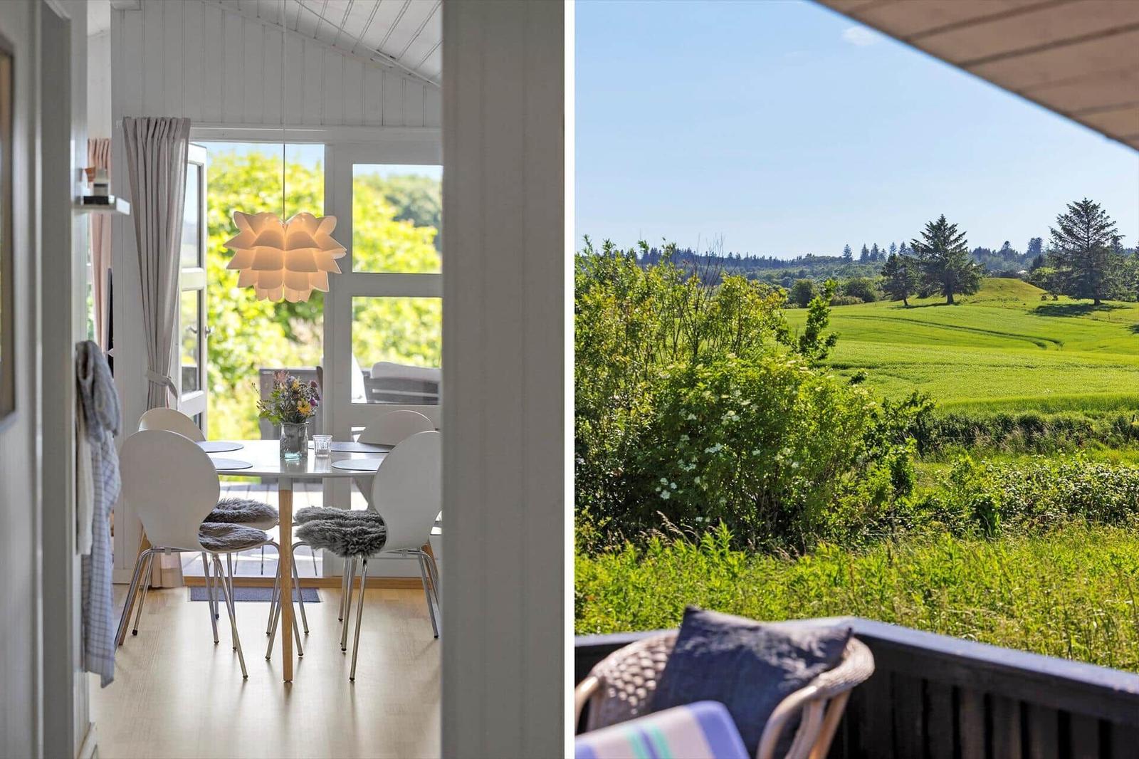 Esszimmer mit Tisch und Stühlen. Aussicht auf grüne Wiesen und Bäume.