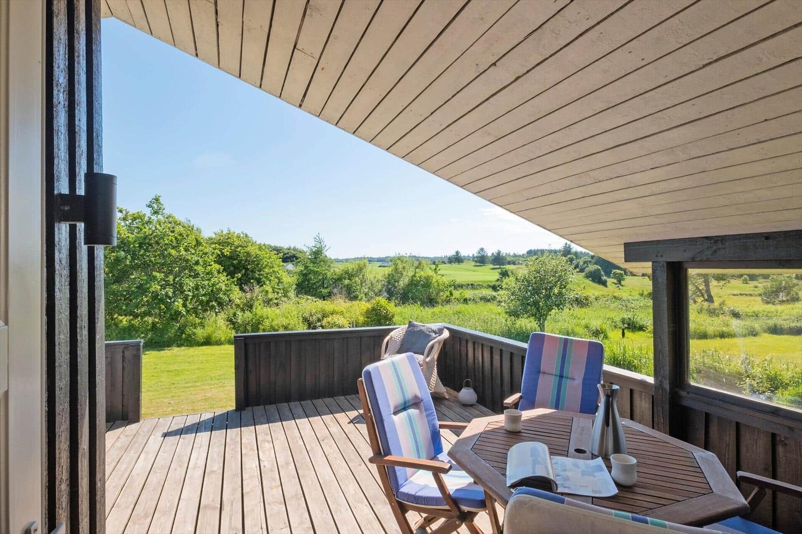 Terrasse mit Sitzgruppe und Blick auf grüne Landschaft.