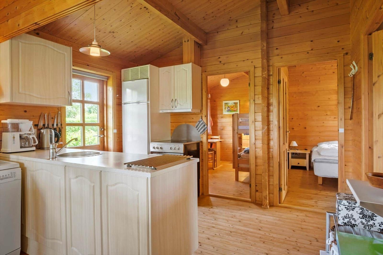 Küche mit Arbeitsplatte, Kühlschrank und Blick in Schlafzimmer