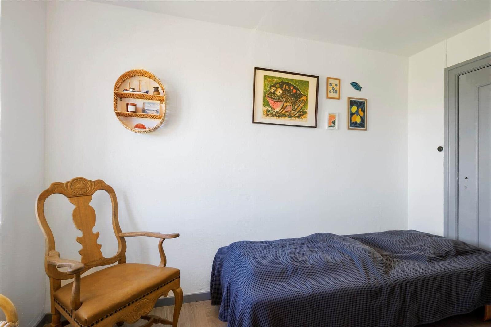 Ein Schlafzimmer mit einem Bett, einem Stuhl und Wanddekoration.