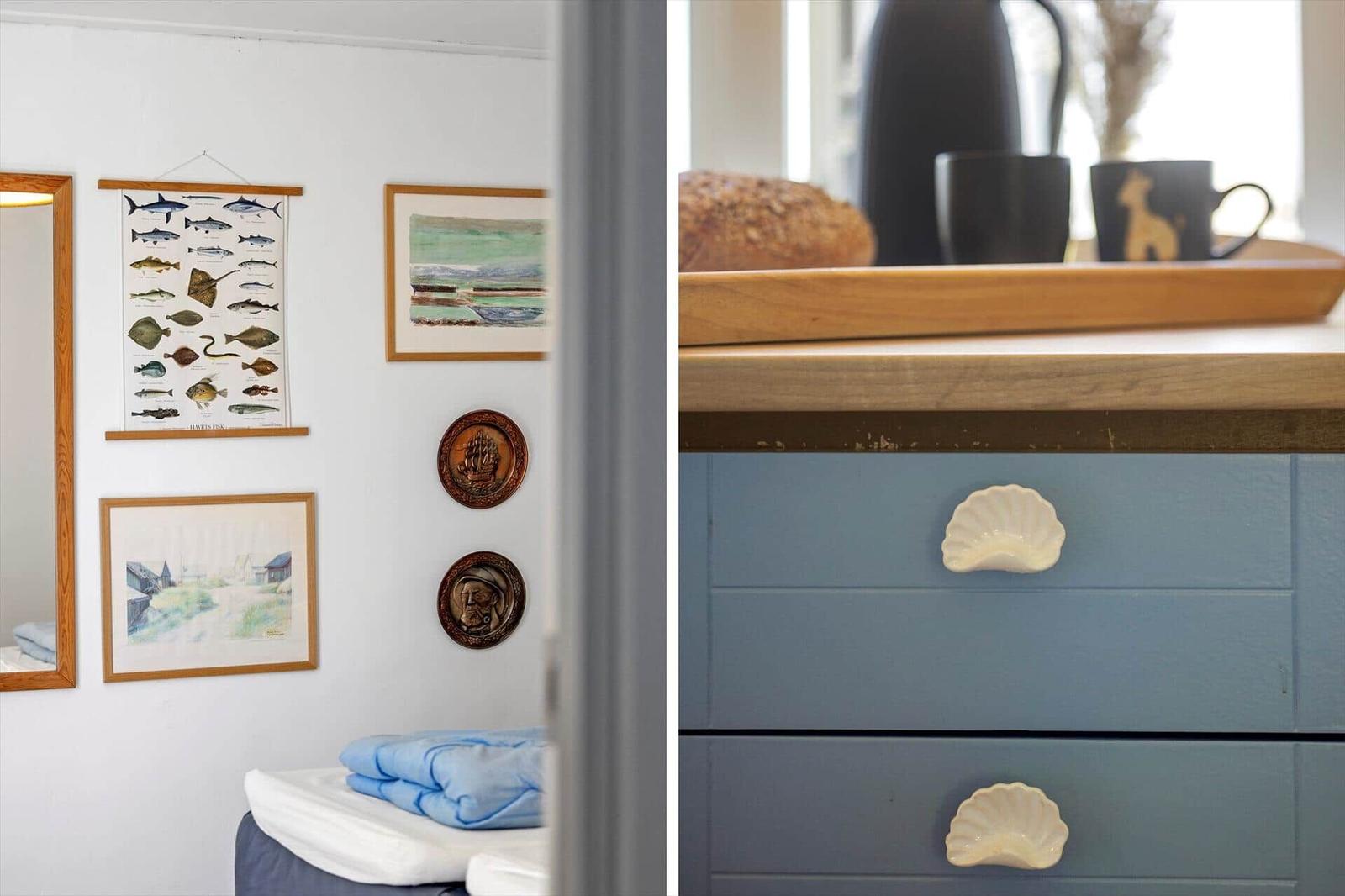 Schlafzimmer mit Wanddekoration und Küchenbereich mit Schubladen mit Muschelgriffen.
