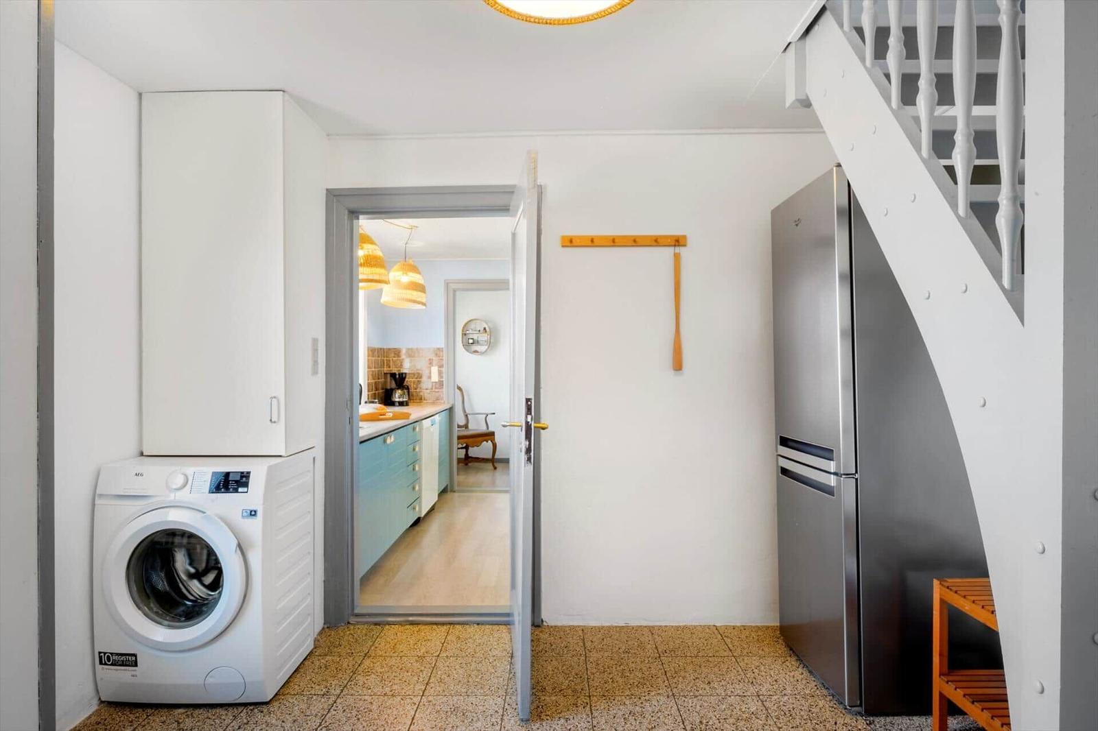Wohnung mit Waschmaschine, Kühlschrank und Treppenhaus.