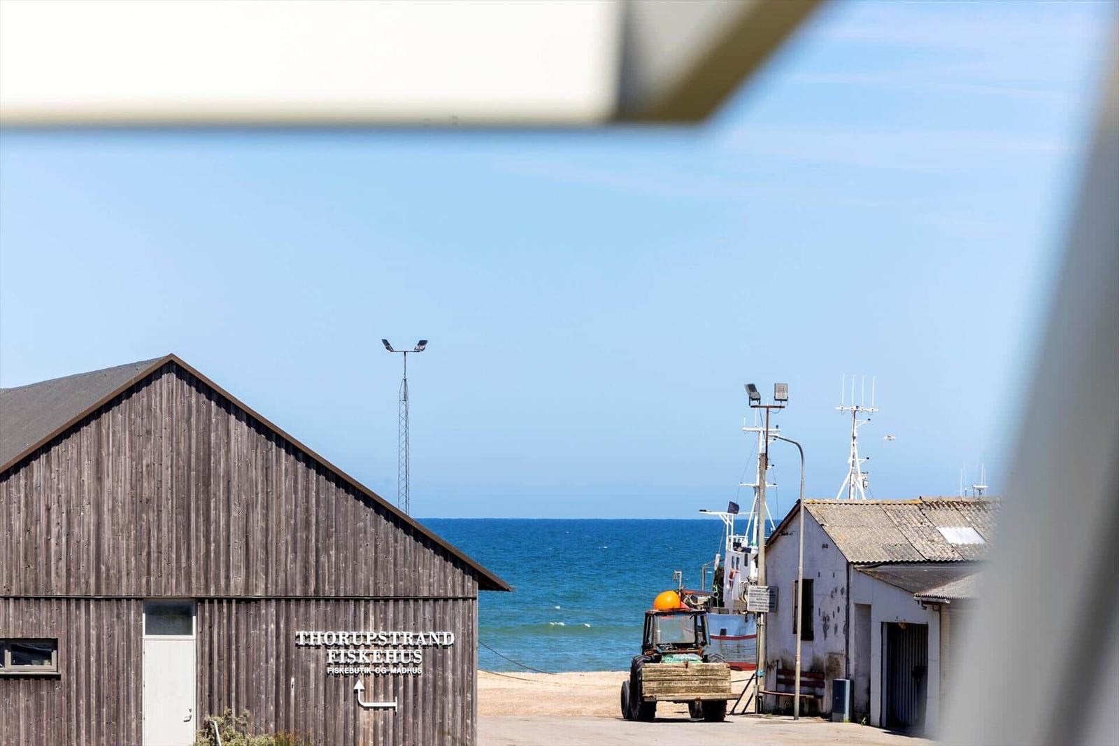 Fischerhaus Thorupstrand mit Blick aufs Meer und Fischerboot.