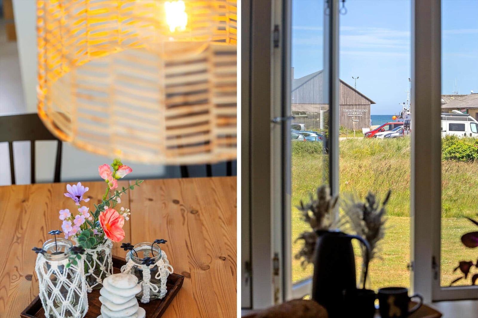 Tisch mit Blumen und Laterne, Blick auf Hafen und Grasland