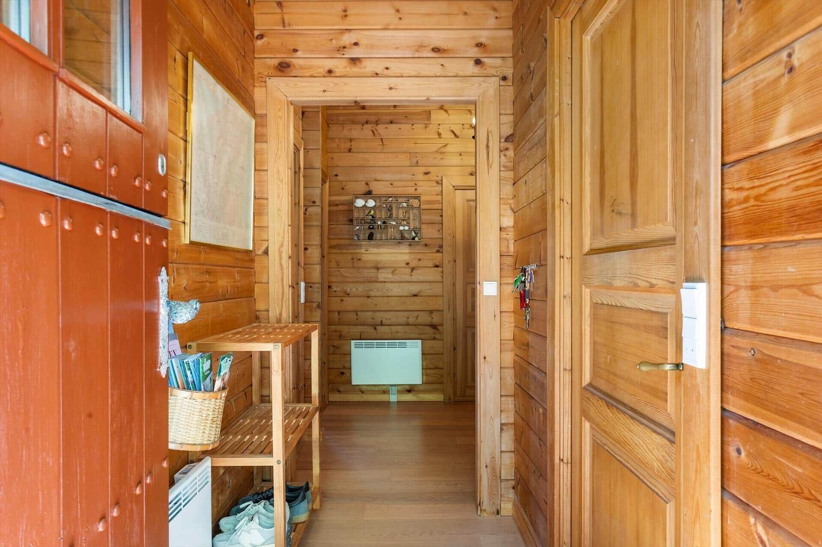 Holzgetäfelte Eingangshalle mit Schuhschrank und Karte an der Wand.