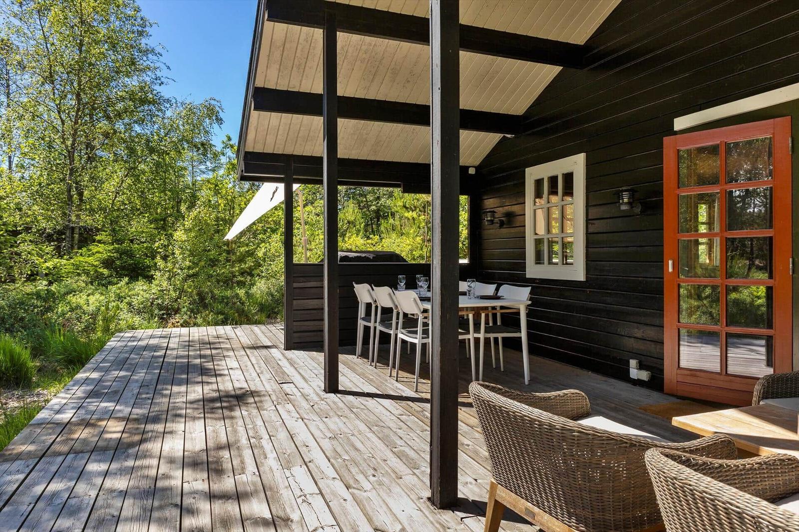 Terrasse mit Tisch, Stühlen und Blick in den Wald