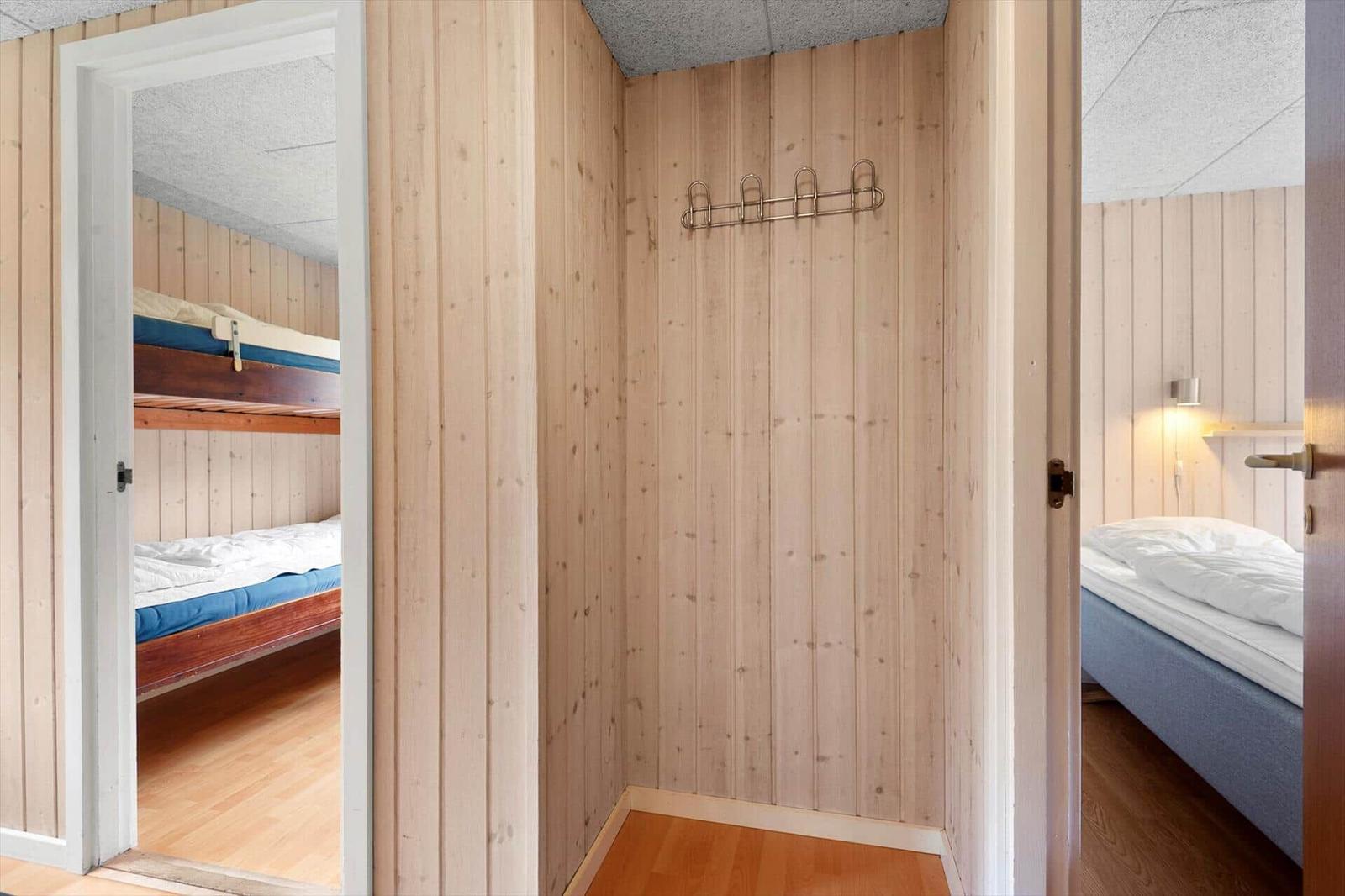 Zimmer mit Schlafplatz und Kleiderhaken an Holzwand