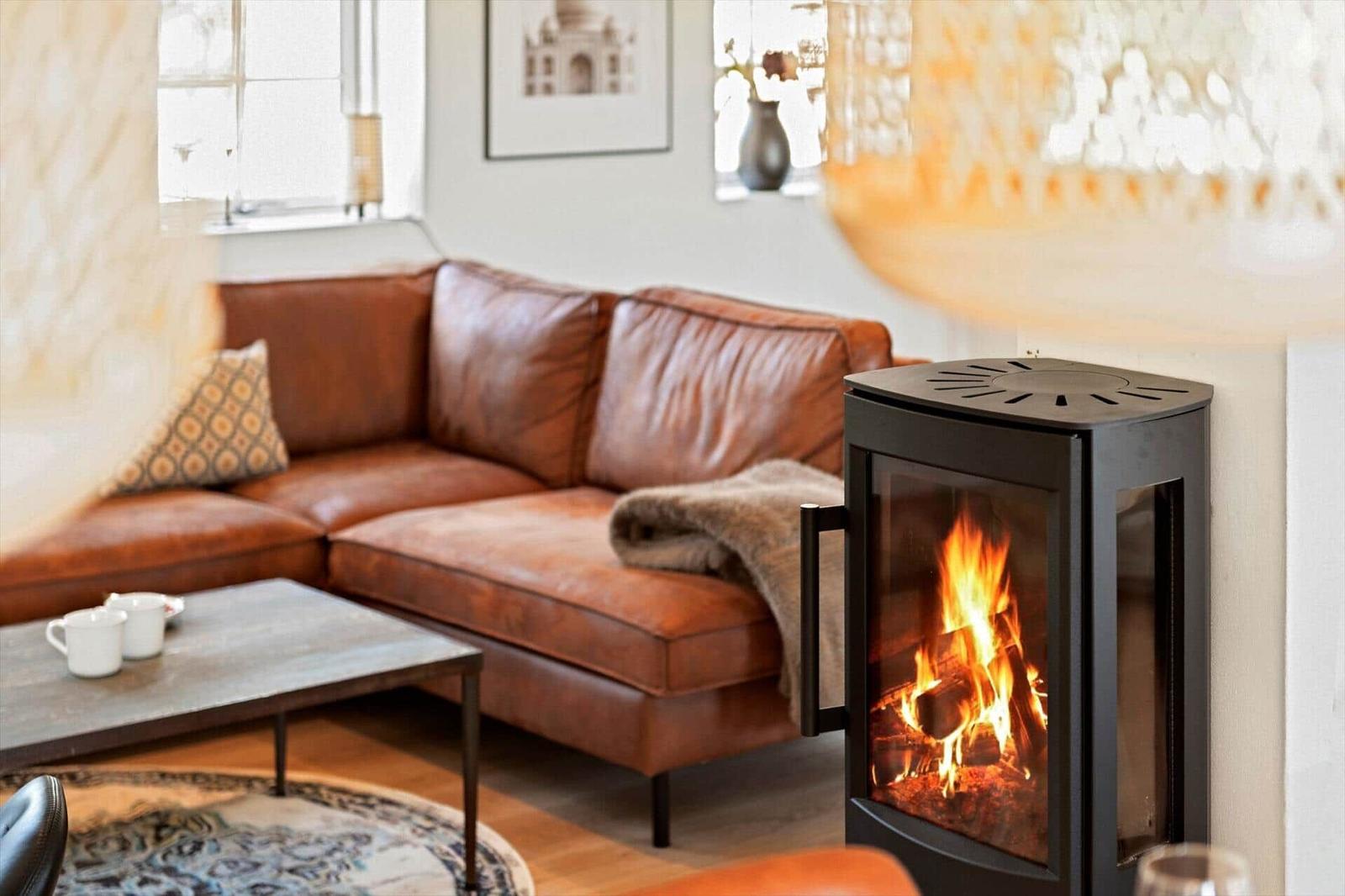 Ein Wohnzimmer mit einem Ledersofa, einem Kamin und einem Tisch mit Tassen.