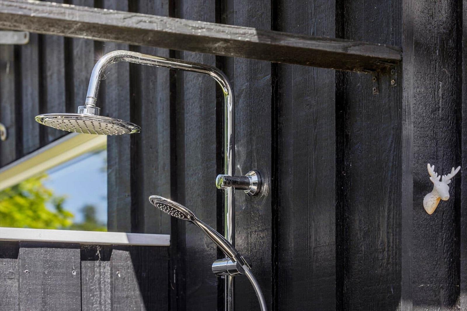 Außen-Dusche mit Duschbrause und Handbrause an schwarzer Holzwand