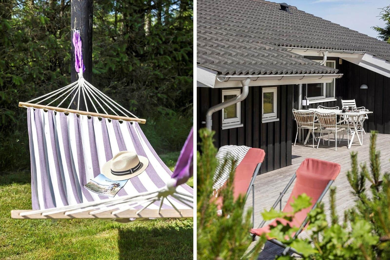 Hängesessel mit Strohhut und Zeitschrift im Garten. Terrasse mit Tisch, Stühlen und Haus.
