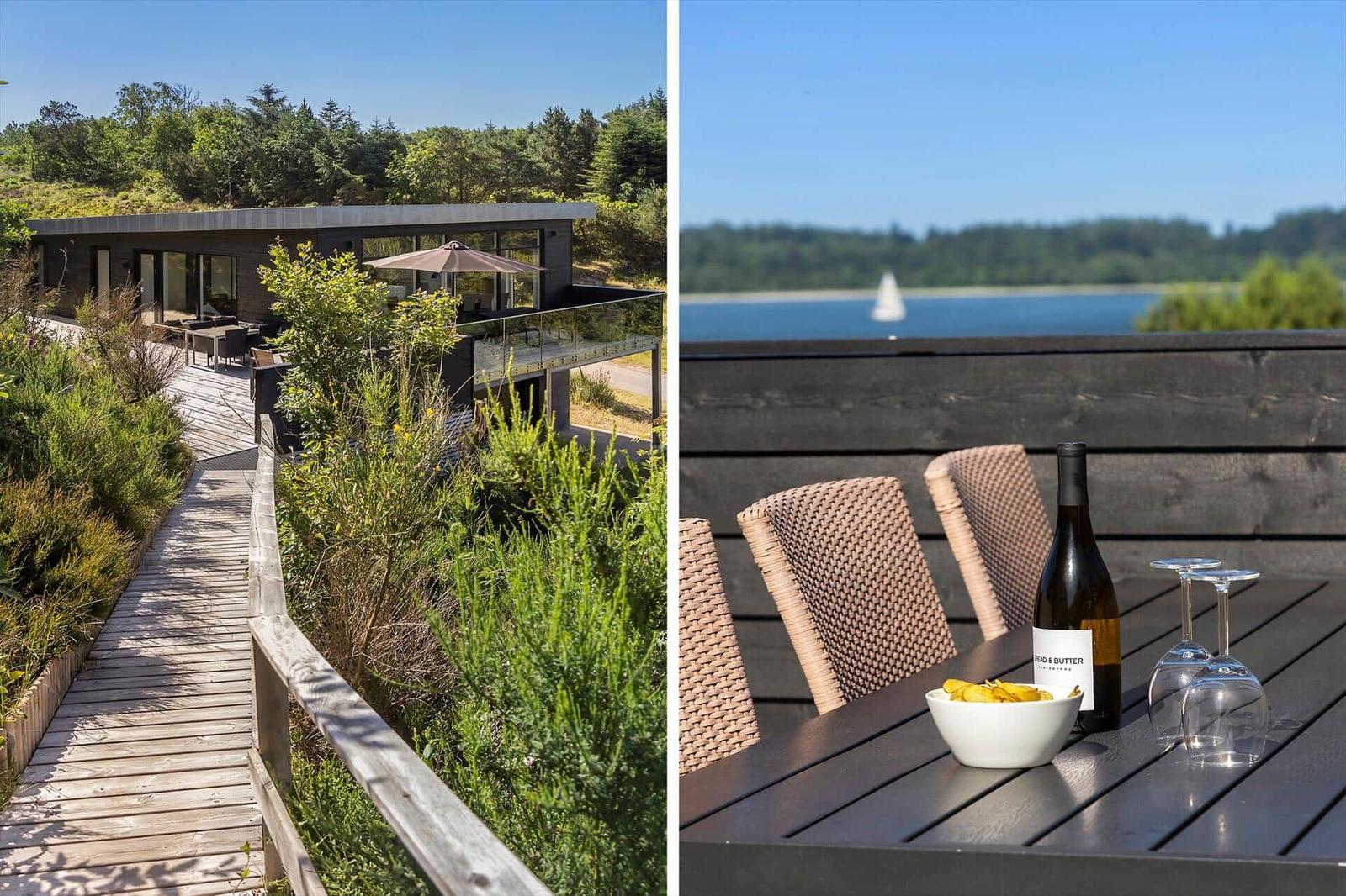 Moderne Villa mit Terrasse und Blick auf Wald und See.