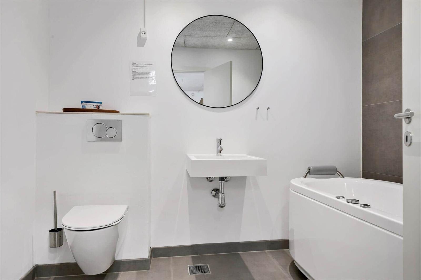 Badezimmer mit Toilette, Waschbecken und Badewanne.