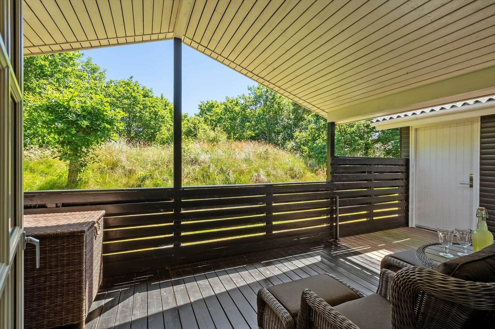Terrasse mit Sitzgelegenheiten und Blick auf grüne Landschaft.