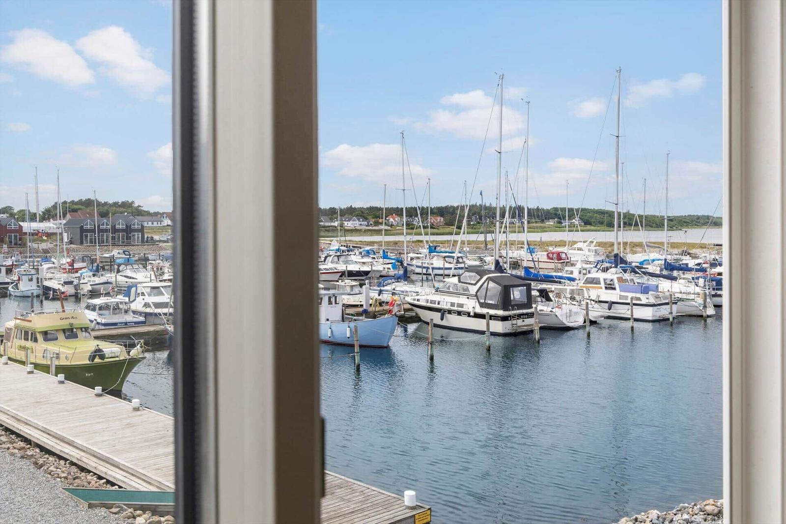 Von einem Fenster aus sieht man einen Hafen mit vielen Booten und Yachten.