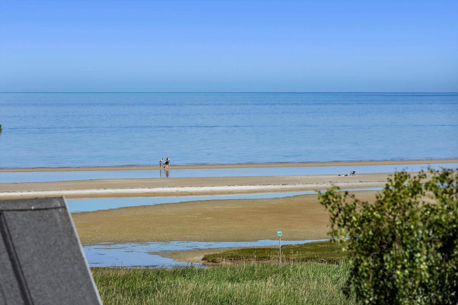 Meeresblick mit Strand und zwei Personen im Wasser