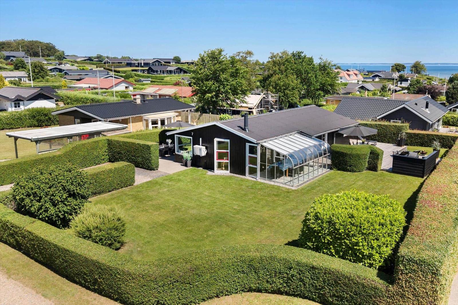 Modern villa with large garden, terrace, and sea view.
