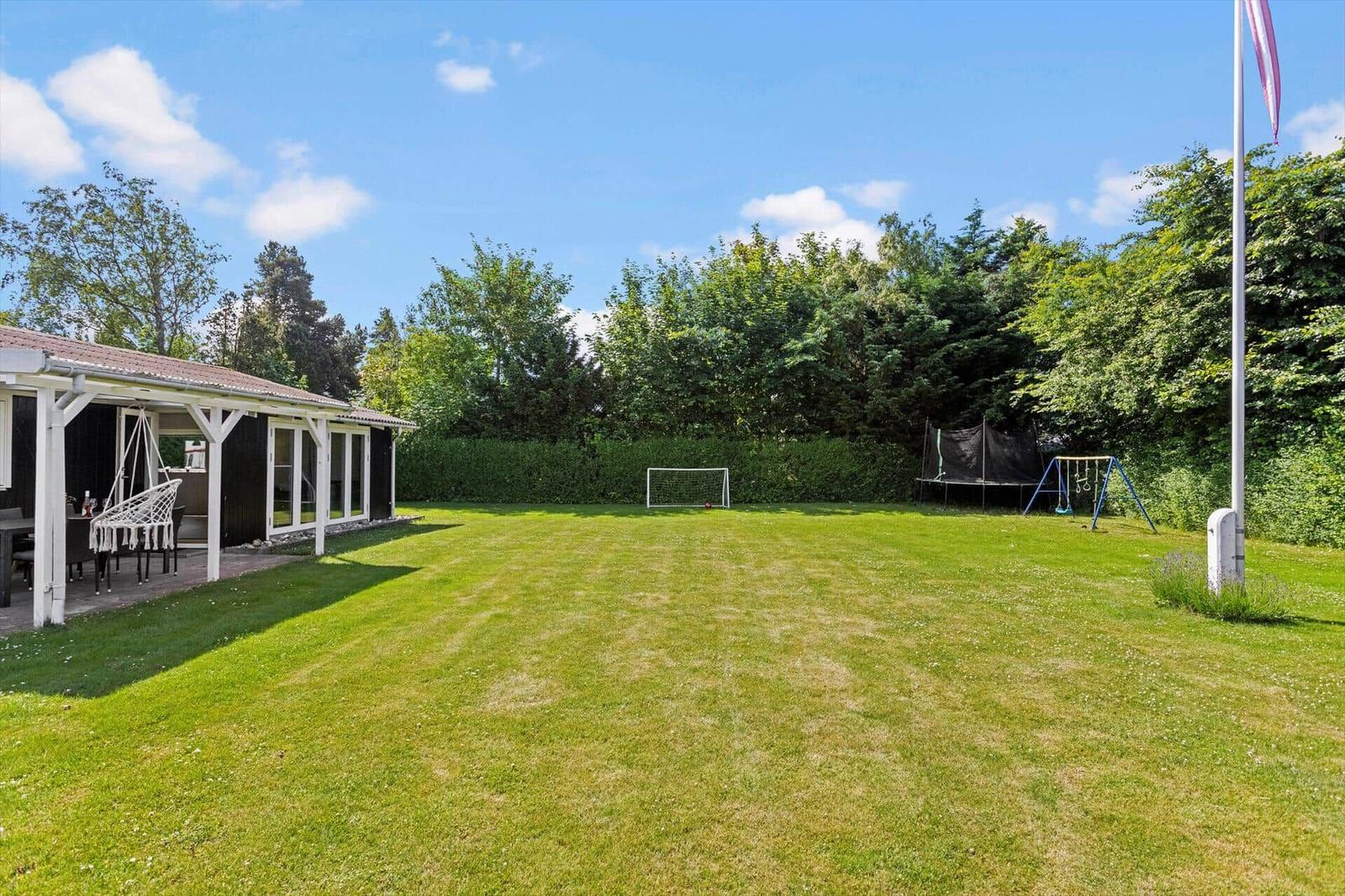 Großer grüner Garten mit Fußballtor, Schaukel und Spielplatz. Hinterhof mit Pavillon und Sitzgelegenheiten.