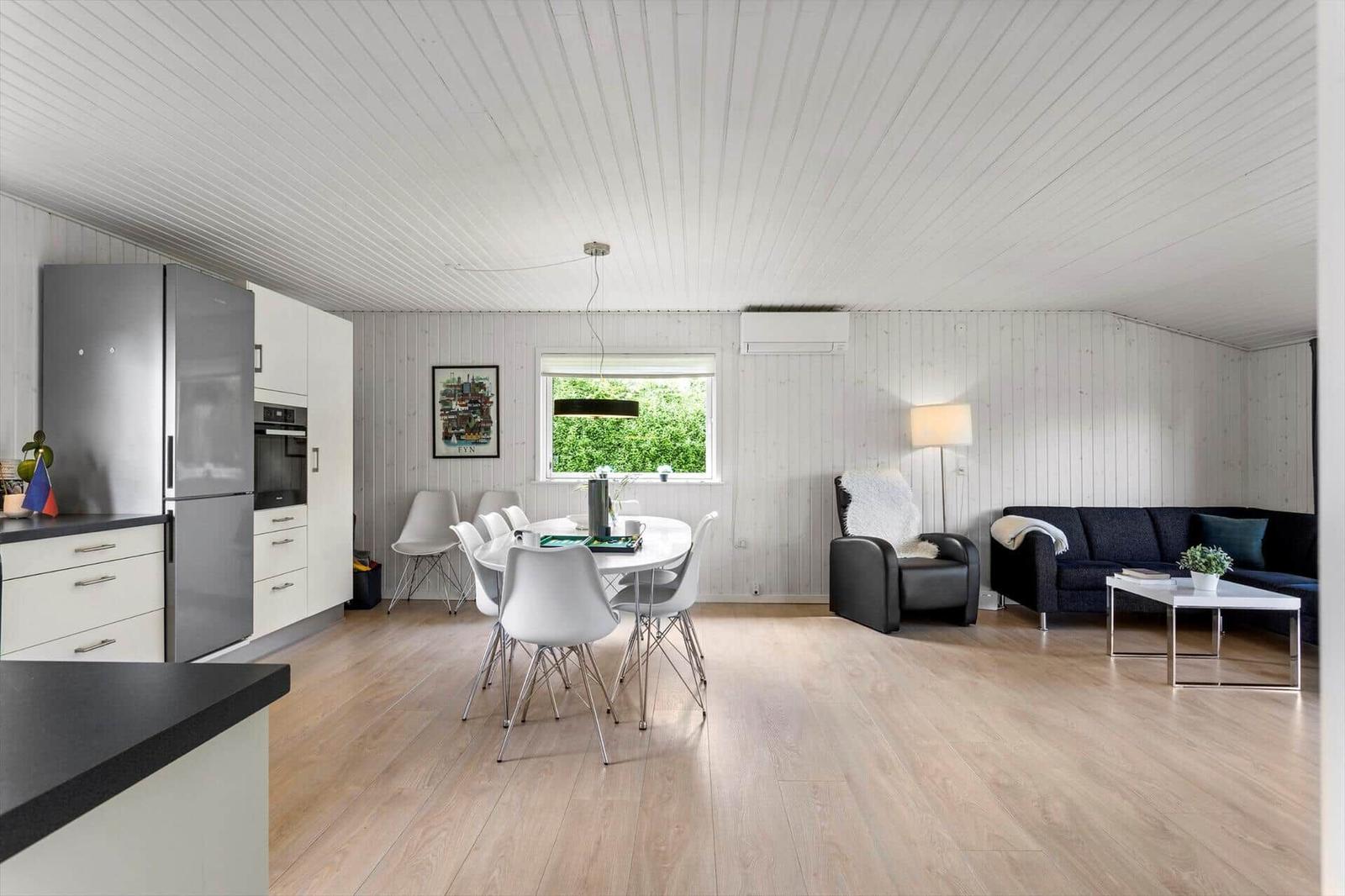 Küche mit Essbereich und Wohnbereich mit Sofa und Sessel.