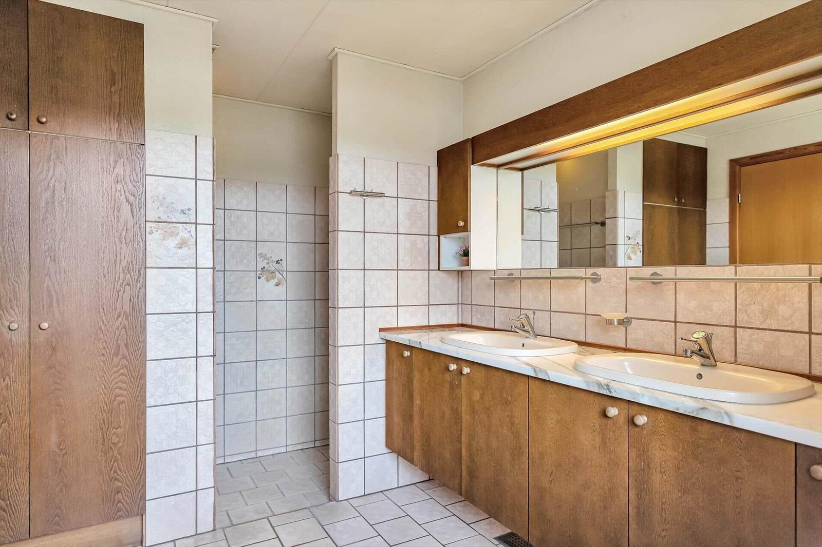 Bathroom with two sinks, mirror cabinet, and shower