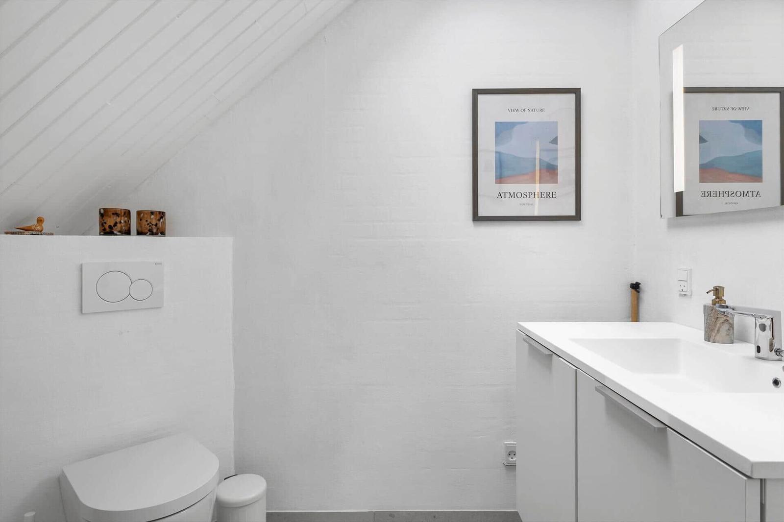 Badezimmer mit Toilette, Waschbecken und Spiegel. Wandbild und Holzdekor.