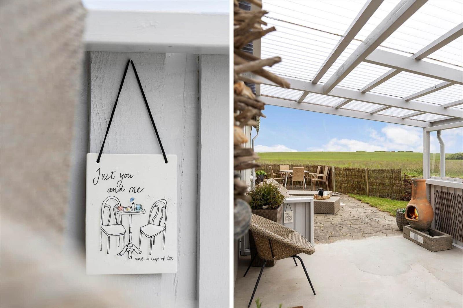 Haus mit Terrasse und Sitzgelegenheiten. Außentisch und -stühle unter einem Dach.