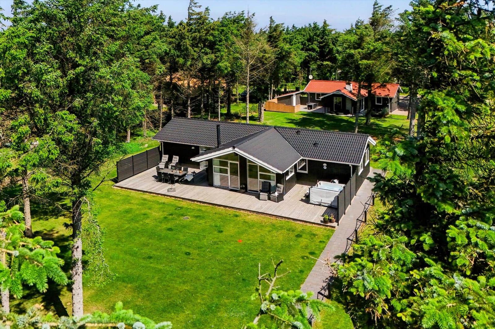 Moderne Villa mit großem Holzterrasse, Grillplatz und Whirlpool im grünen Garten.