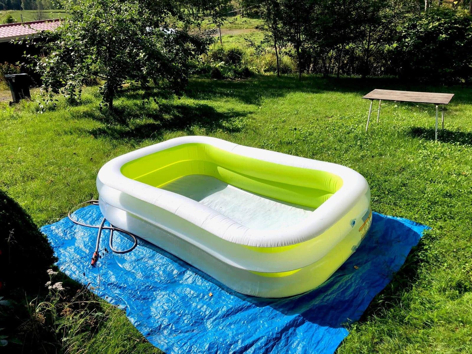 Aufstellpool mit blauer Plane im Garten