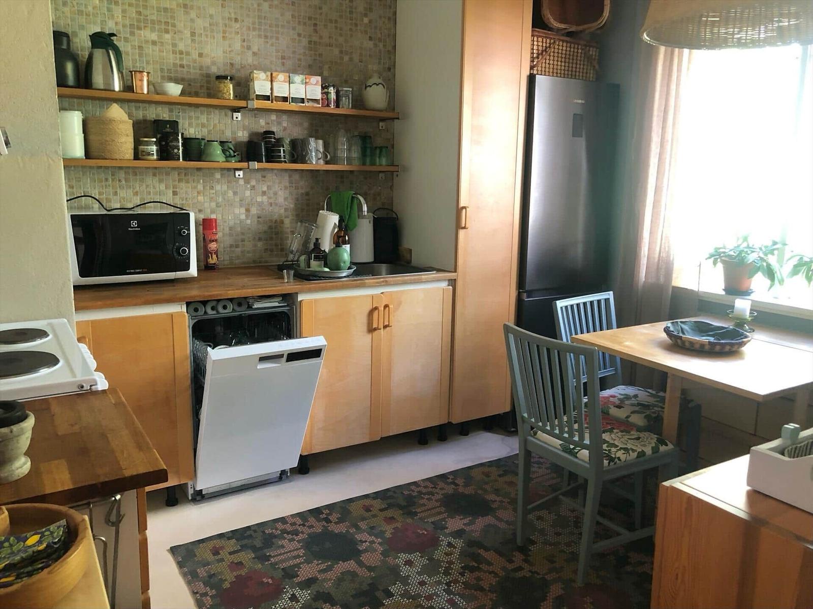 Küche mit Spüle, Kühlschrank, Mikrowelle und Geschirrspüler.