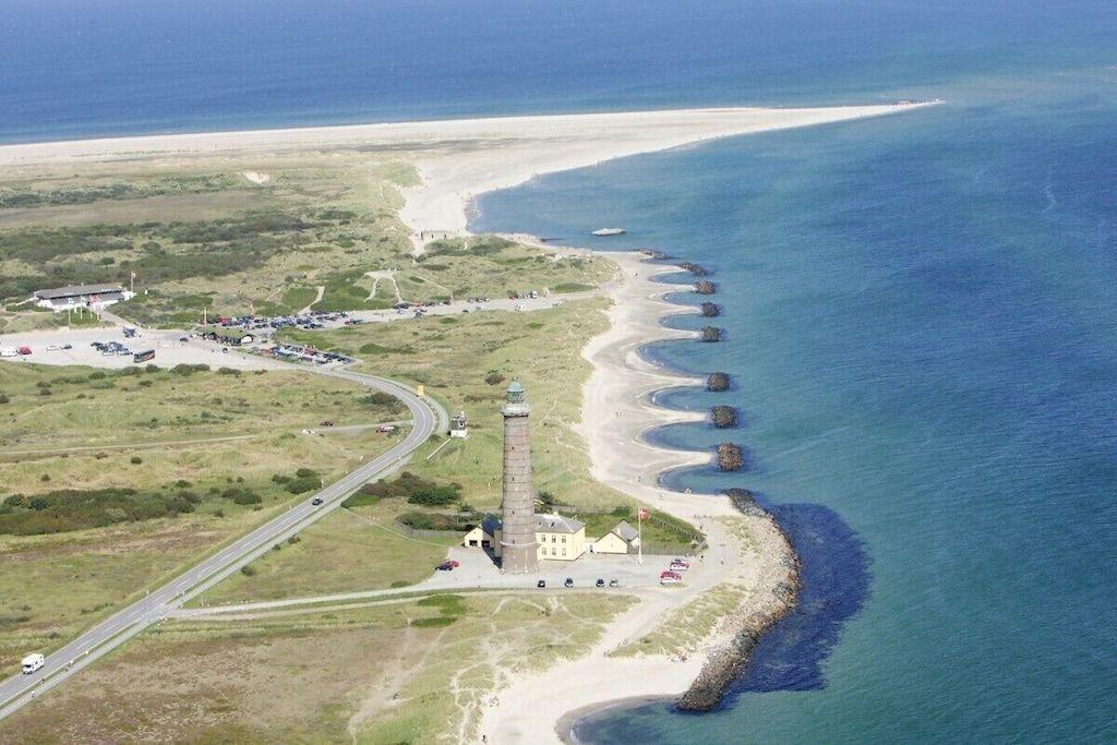 Lichtturm an Küstenstraße mit Strand und Meer