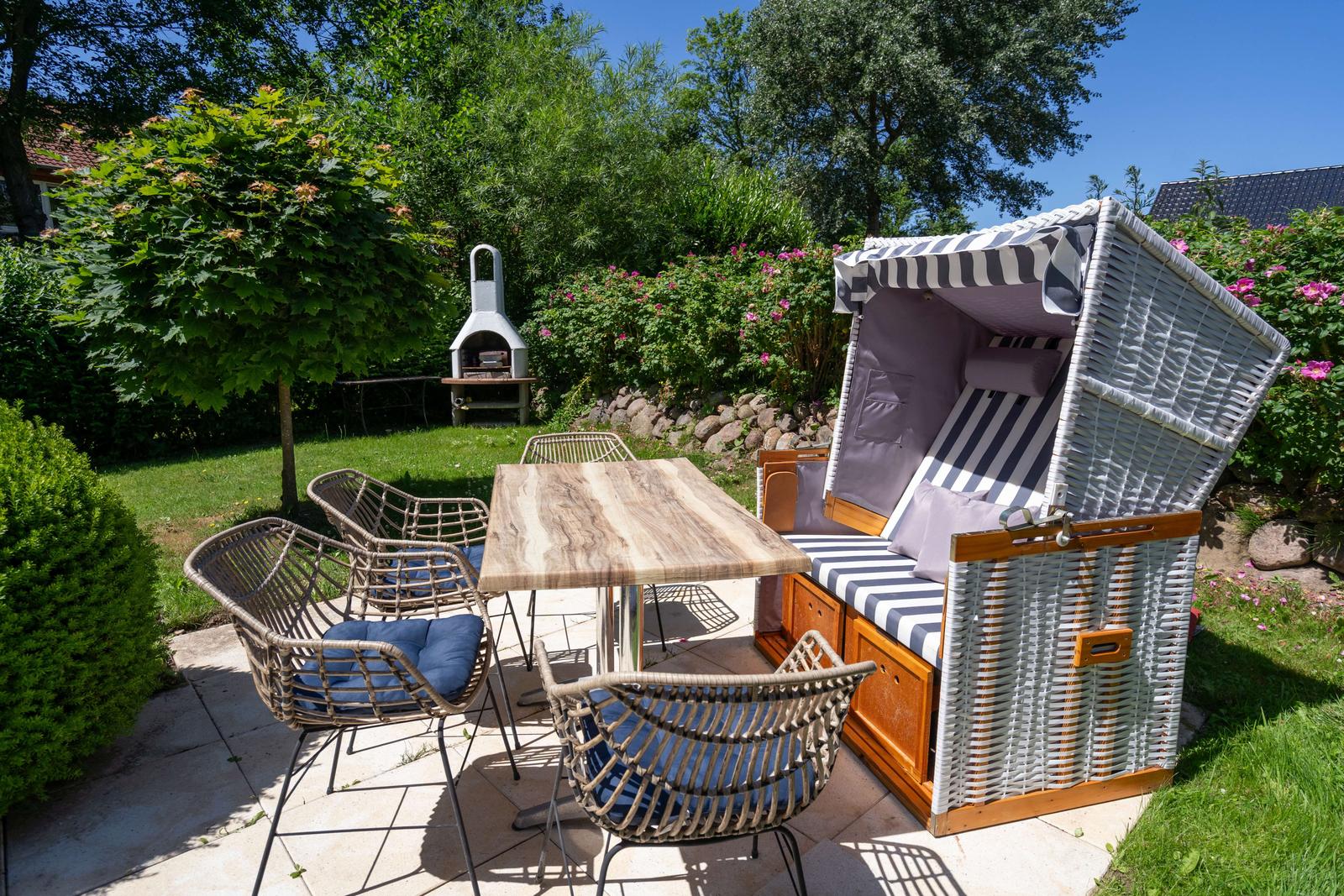 Hinterhof mit Gartenmöbeln, Strandkorb und Grillplatz.
