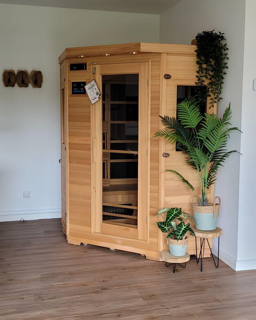 Holzsauna mit Glasfront und Pflanzen im Raum