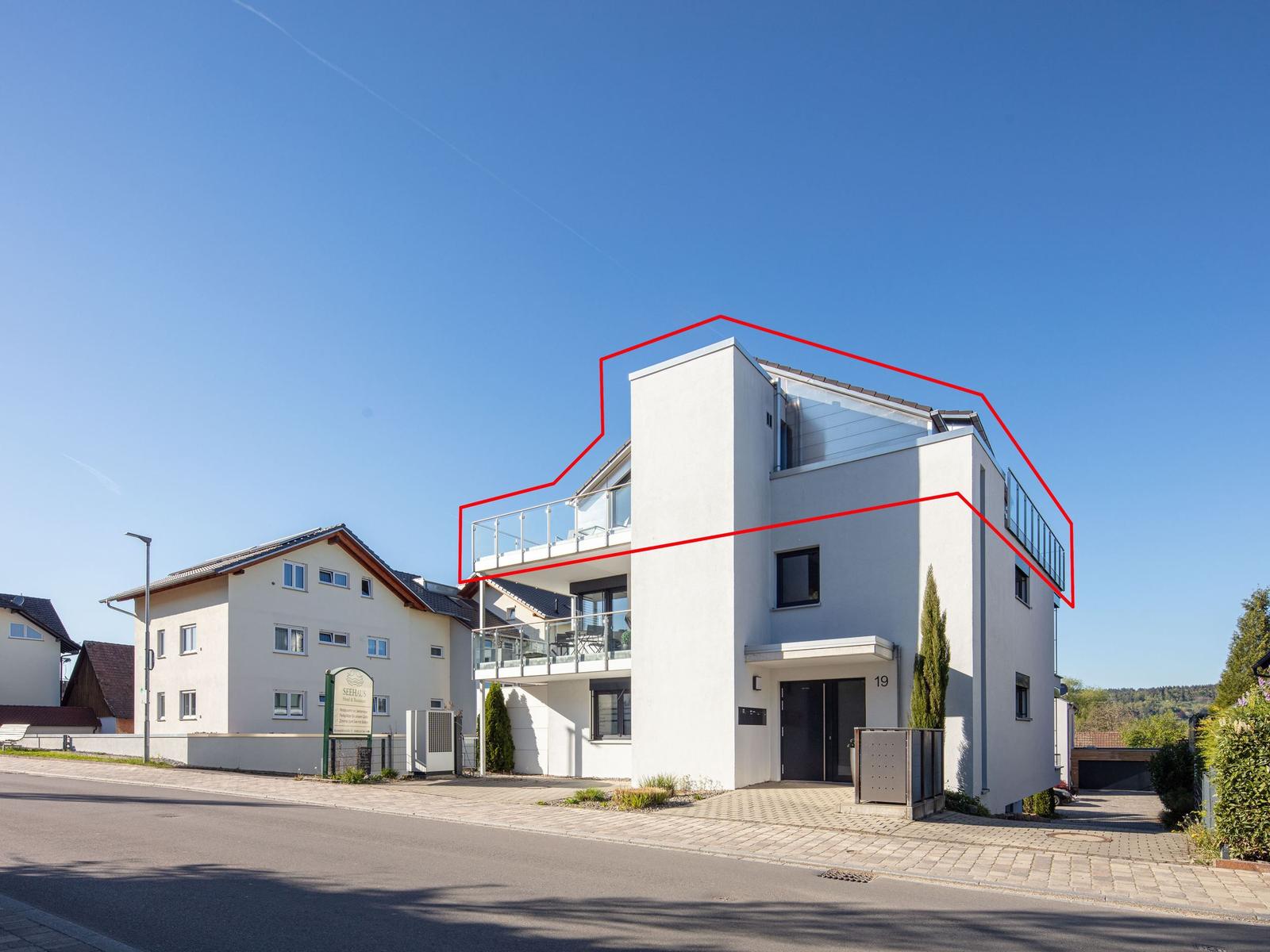 Moderne Wohnung mit Balkon und Glasgeländer, weiß gestrichen, im Stil eines Ferienhauses.