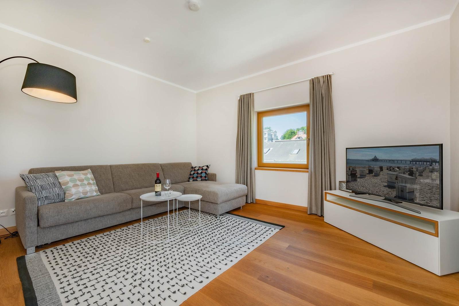Wohnzimmer mit Sofa, Fernseher und Fenster mit Blick.