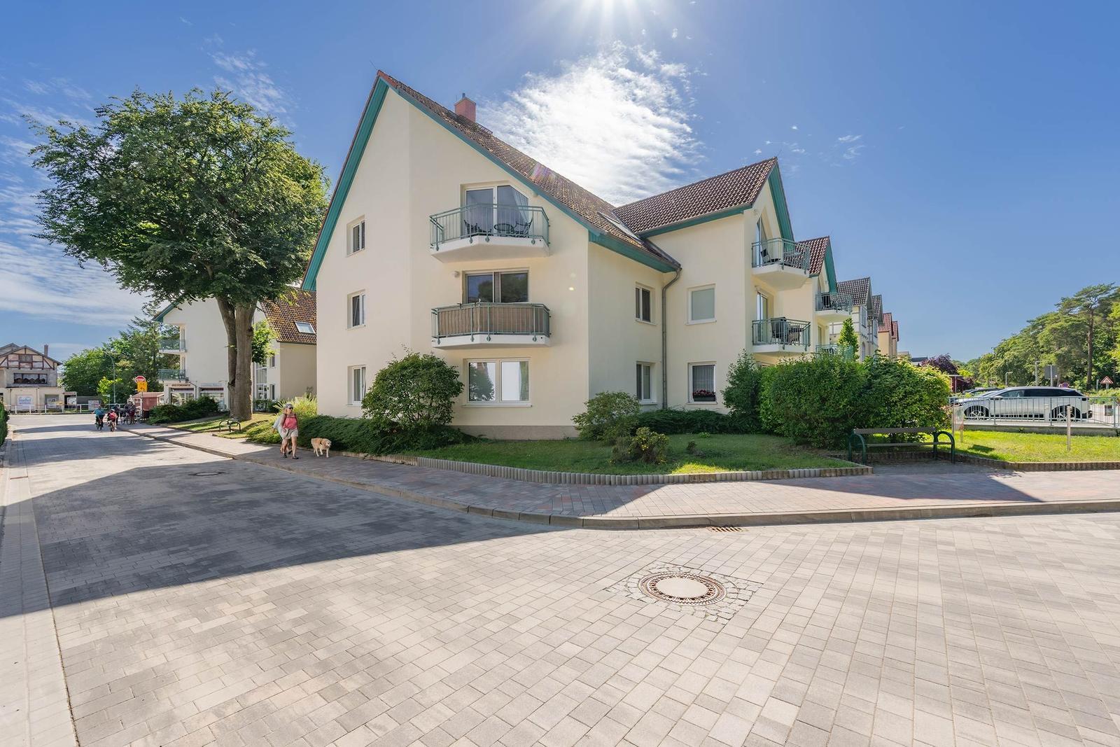 Ein mehrstöckiges Wohnhaus mit Balkonen und grüner Umgebung.