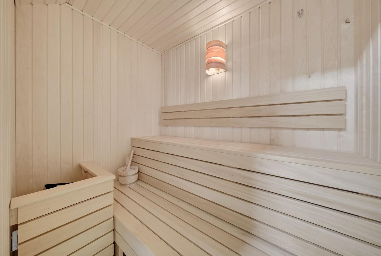 Sauna mit Holzbank und Wandbeleuchtung