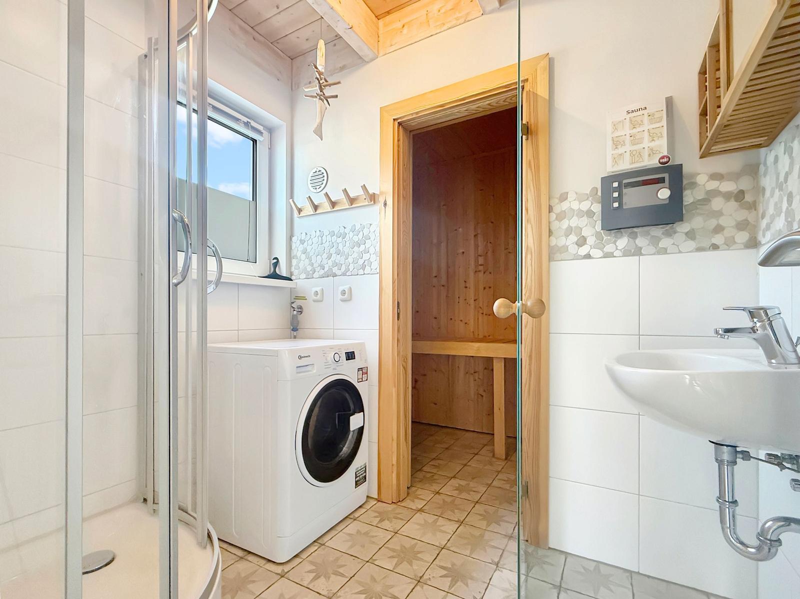 Badezimmer mit Sauna, Waschmaschine und Dusche