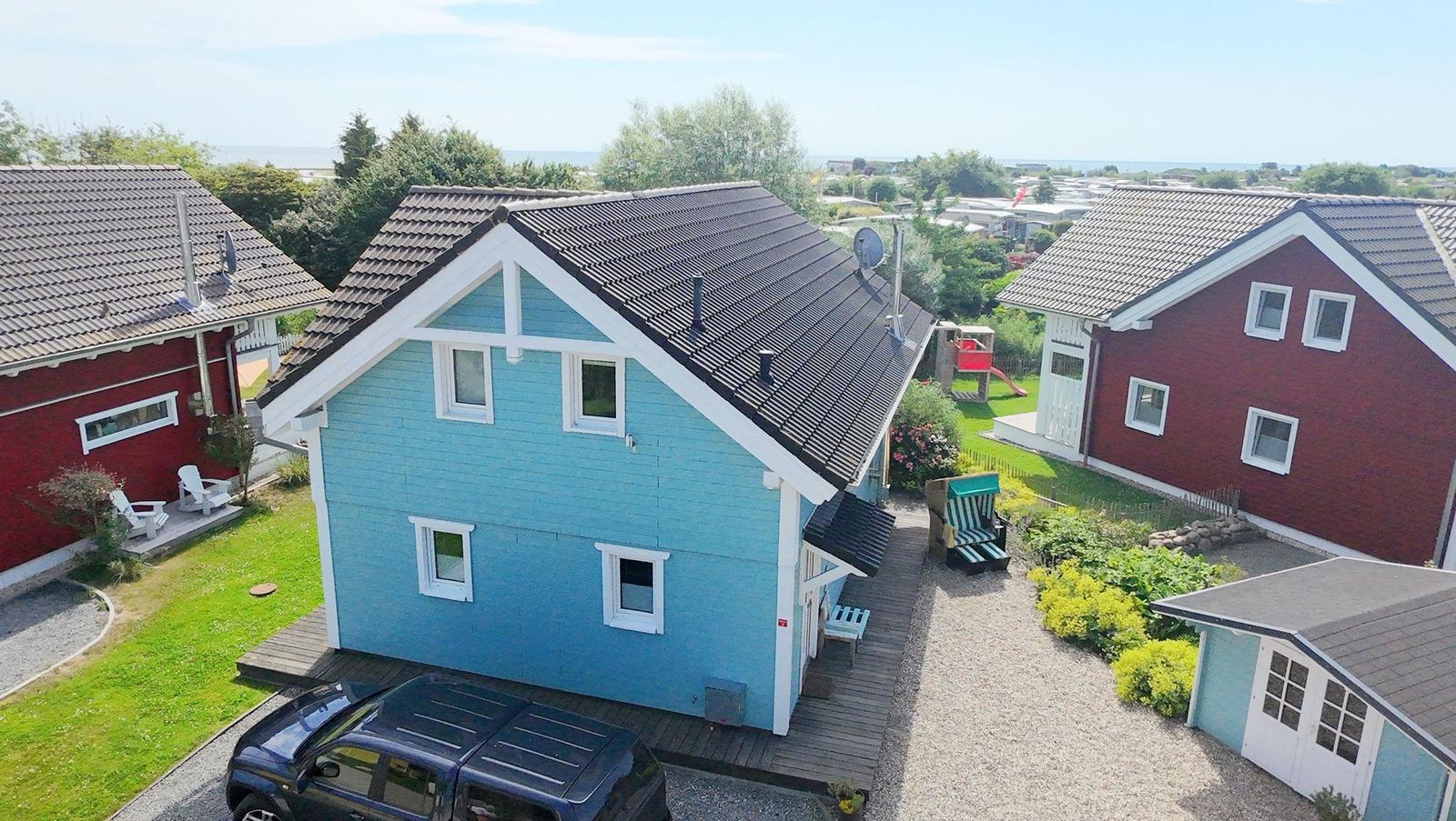 Blau gestrichenes Haus mit Garten und Blick aufs Meer