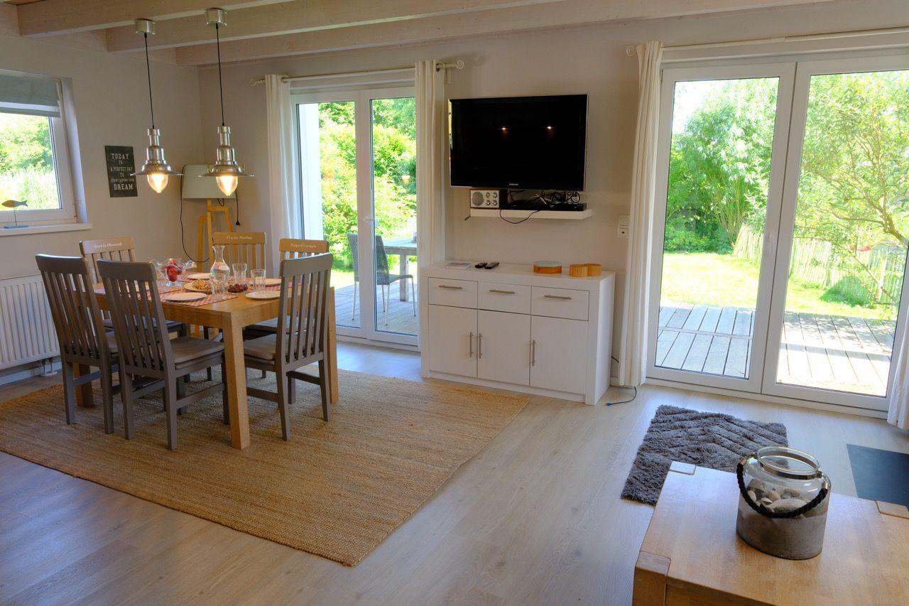 Essbereich mit Tisch, Stühlen und TV. Durchgang zu Terrasse mit Gartenblick.