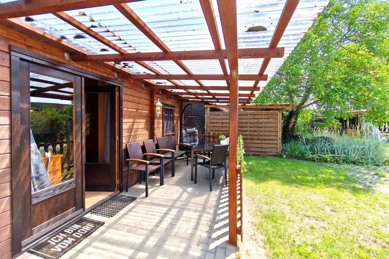 Sonnenterrasse mit direktem Blick in den grünen Garten des Ferienobjekts