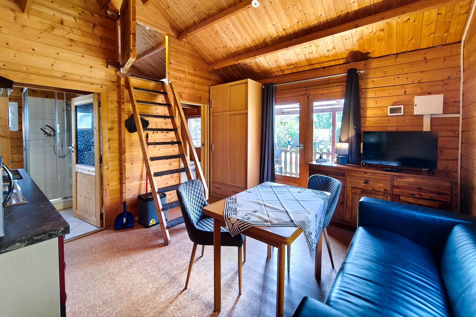 Gemütliches Wohnzimmer im rustikalen Holzblock-Stil des Ferienbungalows Seestern
