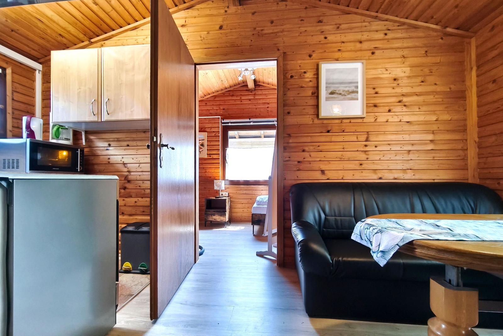 Wohnraum mit Sofa, Küchenzeile und Blick in Schlafzimmer