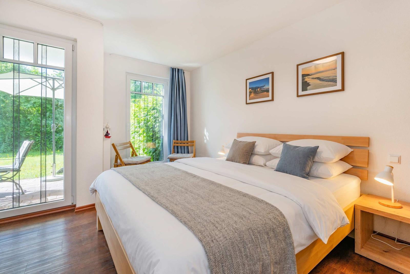 Schlafzimmer mit Bett, Fenster und Terrasse