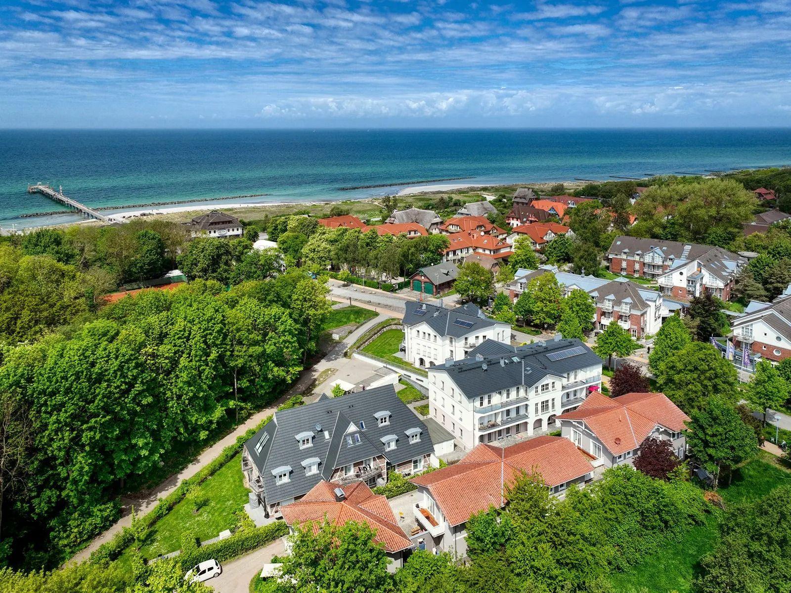 Meerblick auf Strandort mit Häusern und grünen Bäumen