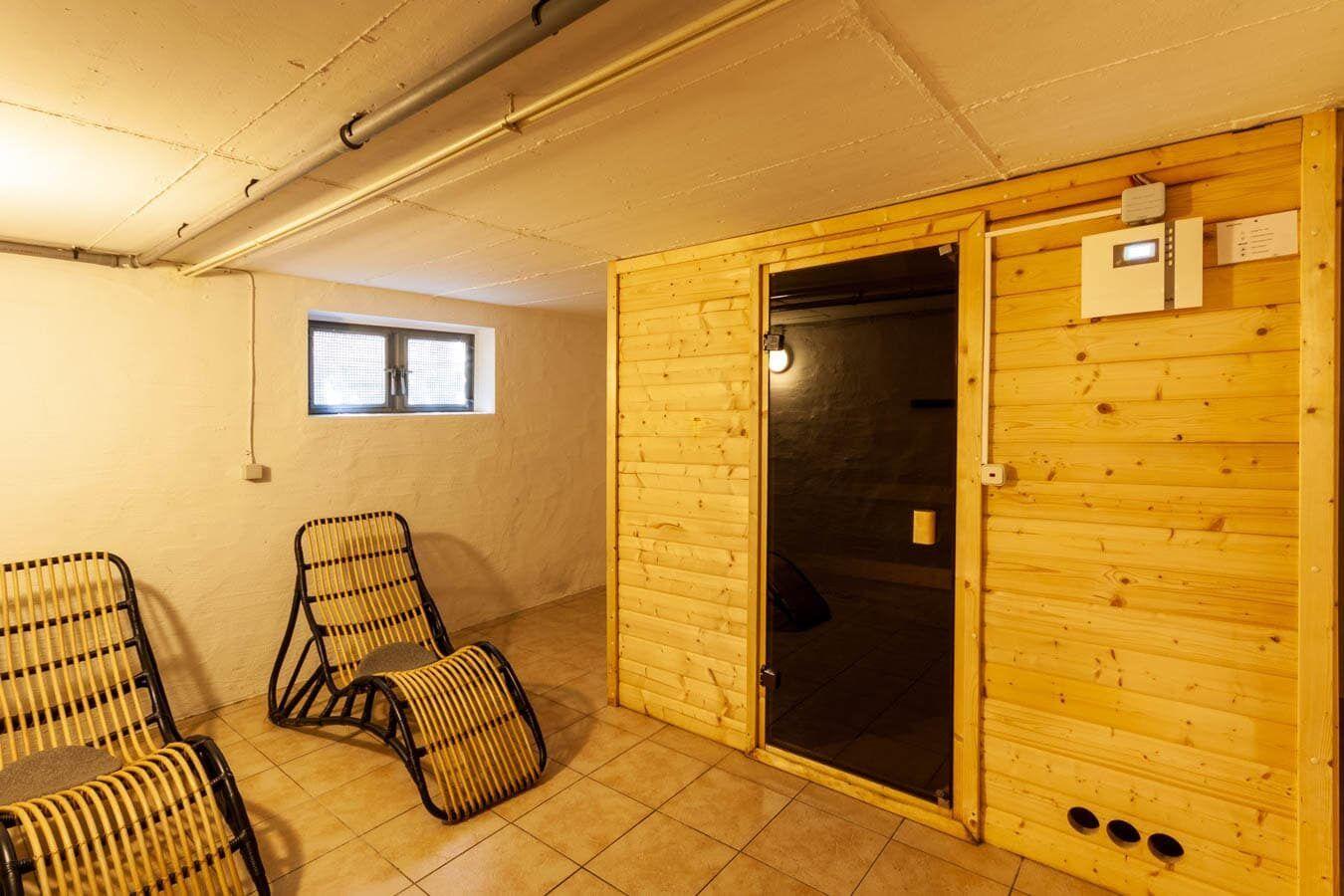 Saunaraum mit Holzwand, zwei Liegestühlen und Fenster