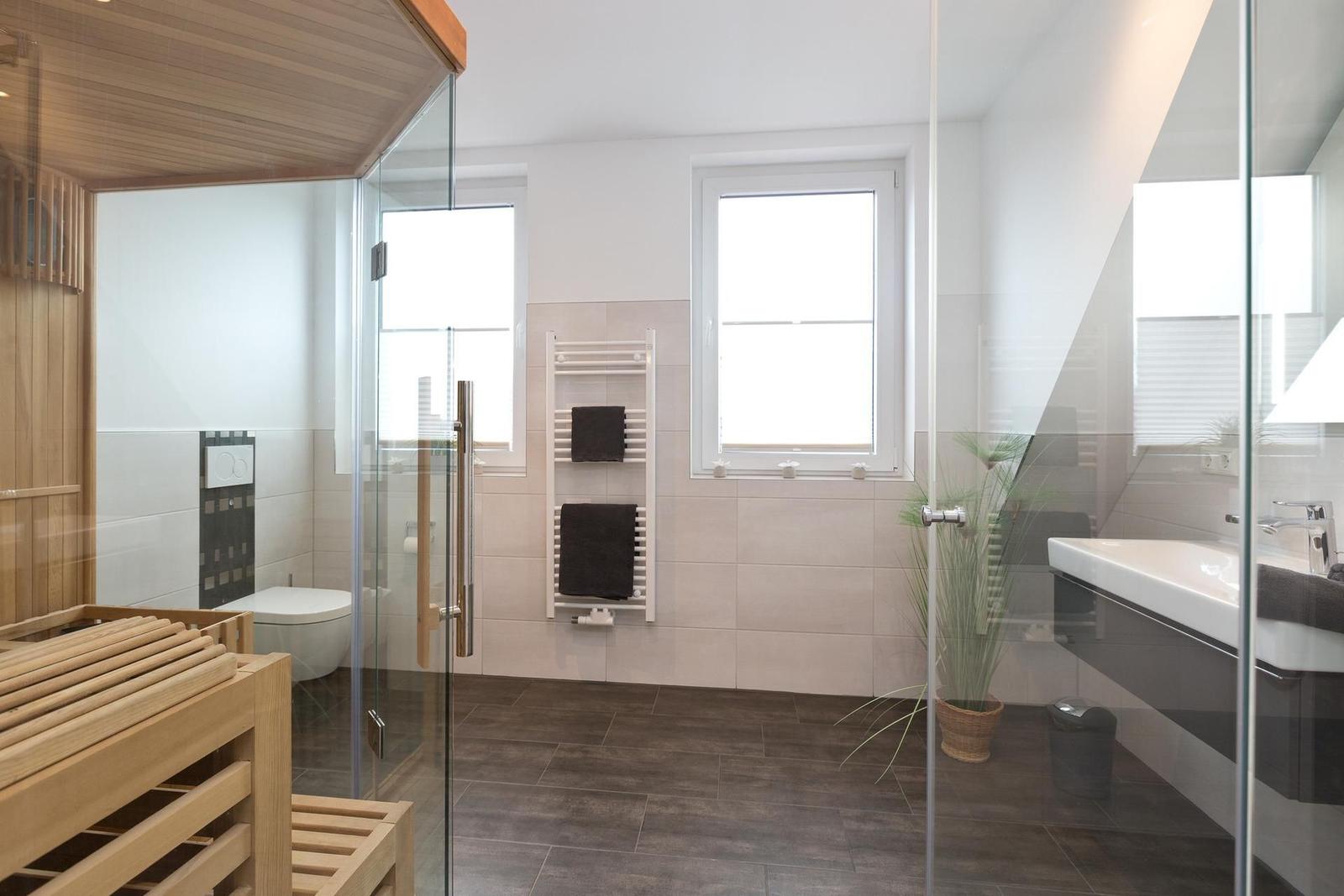 Badezimmer mit Sauna, Dusche, Toilette und Waschbecken