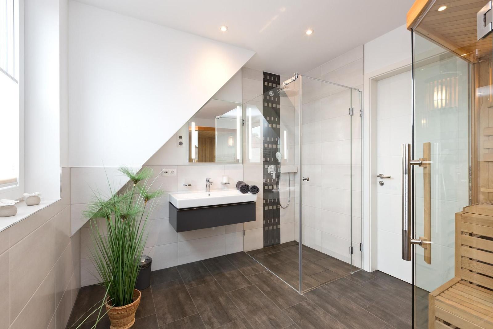 Badezimmer mit Dusche, Waschbecken und Sauna